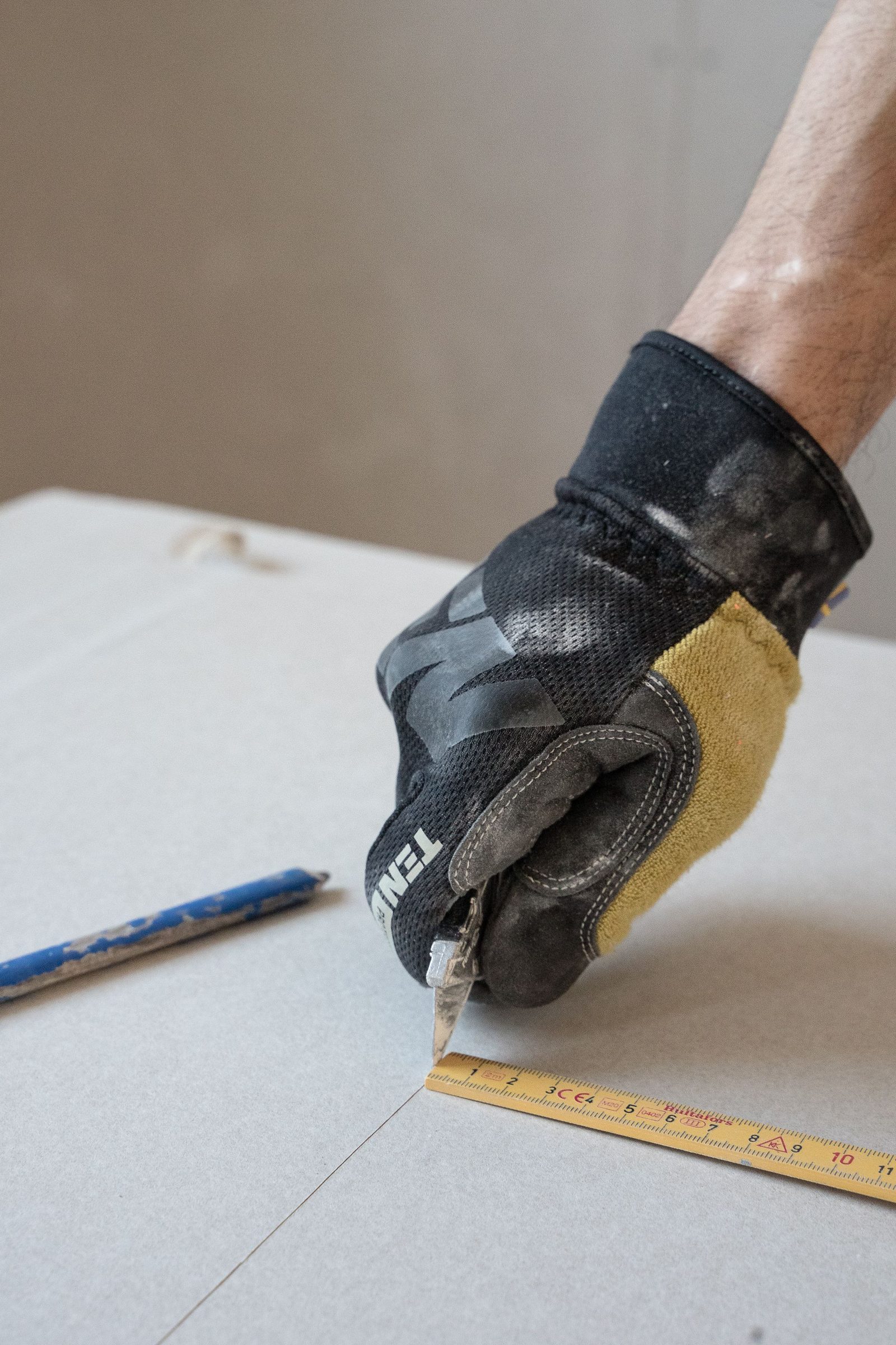 Gloved hand finishing the edge of an insulation board